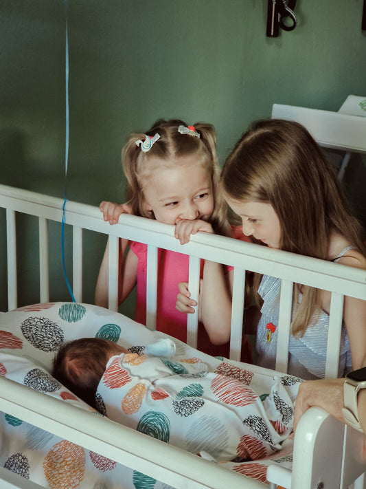 drap housse bébé plié proprement sur un lit blanc avec motifs doux