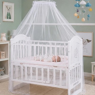 bébé moustiquaire blanc recouvrant un nourrisson endormi dans un berceau