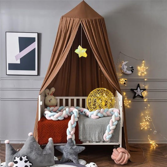 Ciel de lit bébé brun  au-dessus d'un berceau illuminé