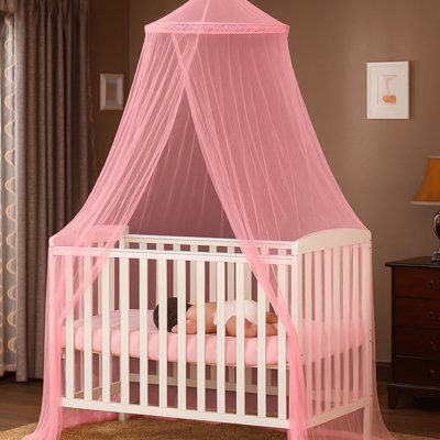 Ciel de lit bébé rose bonbon abritant un nourrisson endormi sur le ventre