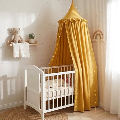 Ciel de lit jaune suspendu au-dessus du berceau d'un bébé