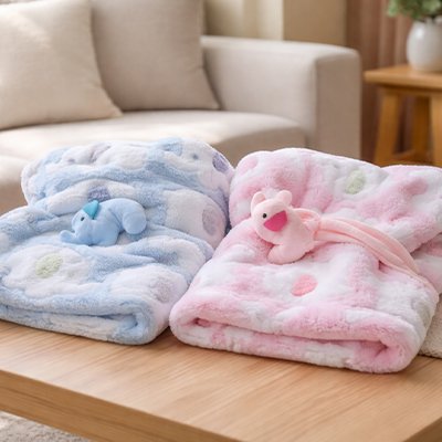Couverture bébé bleu et rose posé sur table