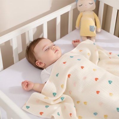 Couverture bébé motifs cœurs multicolores sur nourrisson endormi