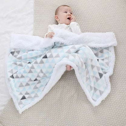 Couverture bébé naissance bleu ciel avec enfant allongé sous triangles