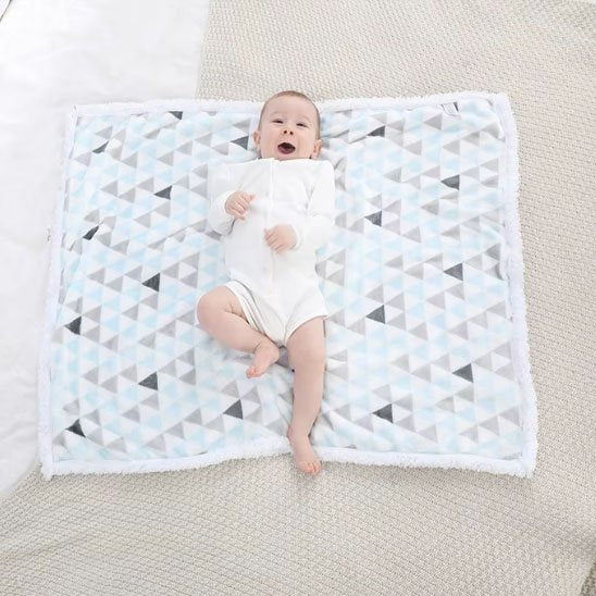 Couverture bébé naissance bleu ciel avec enfant souriant posé dessus