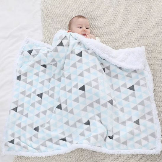 Couverture bébé naissance bleu ciel dépliée avec enfant caché sous tissu