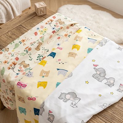 Drap housse lit bébé éléphant fleur et chat sur table