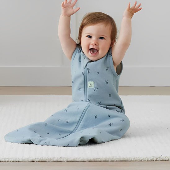 Gigoteuse enfant assit levé les mains au niveau la tête