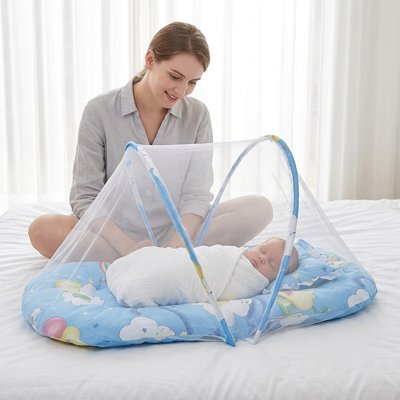 Lit moustiquaire bebe bleu maman assis jambe croise sourit