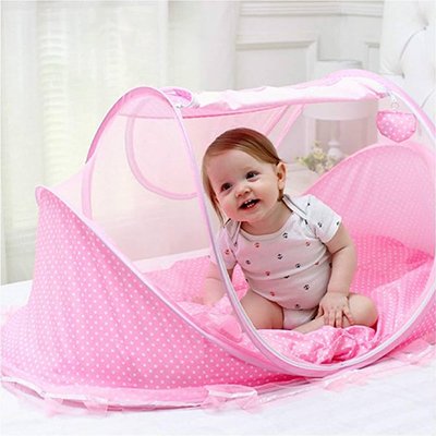 Lit moustiquaire bébé rose assis à l'intérieur sourit  