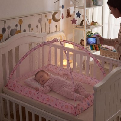 moustiquaire pour lit bébé rose maman observe enfant avec camera