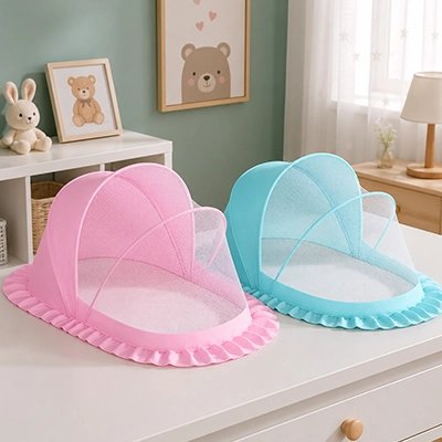 Moustiquaires lit bébé déclinés en modèles rose et bleu sur un meuble