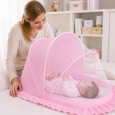 Moustiquaires lit bébé  rose abritant un nourrisson endormi sur un grand lit