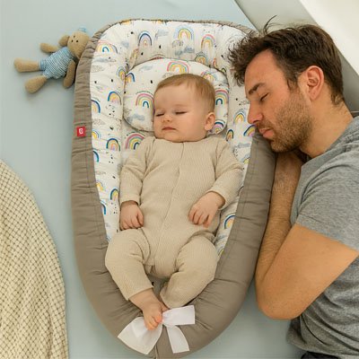 Reducteur de lit arc-en-ciel avec papa et bébé endormi
