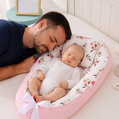 Reducteur de lit fleurs roses avec papa et bébé endormi