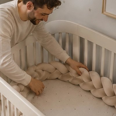 Tresse de lit beige installée par un papa souriant