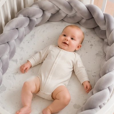 Tresse de lit gris bébé couché dans lit
