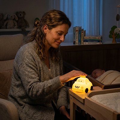 Veilleuse bébé maman souriante en touchant le bouton allumage 